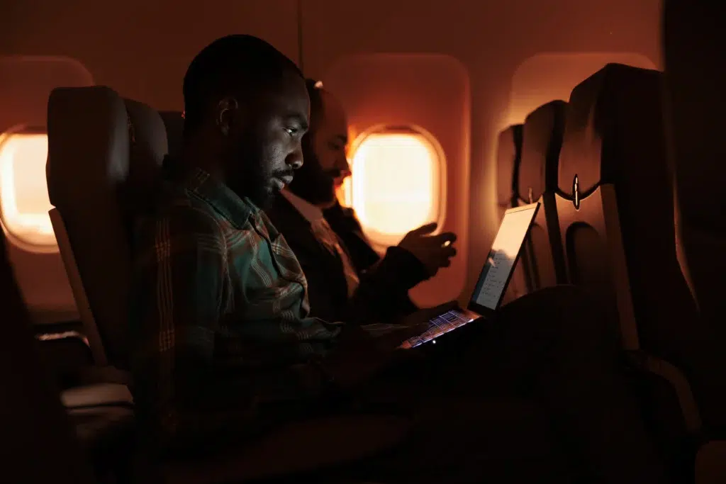 a man using a laptop on an airplane
