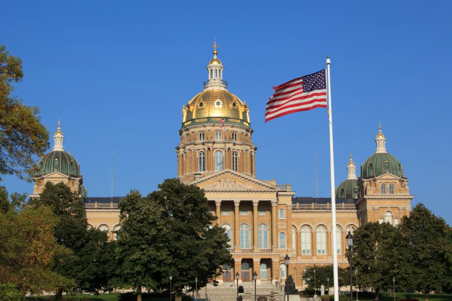 a flag flying in front of Iowa State Capitol